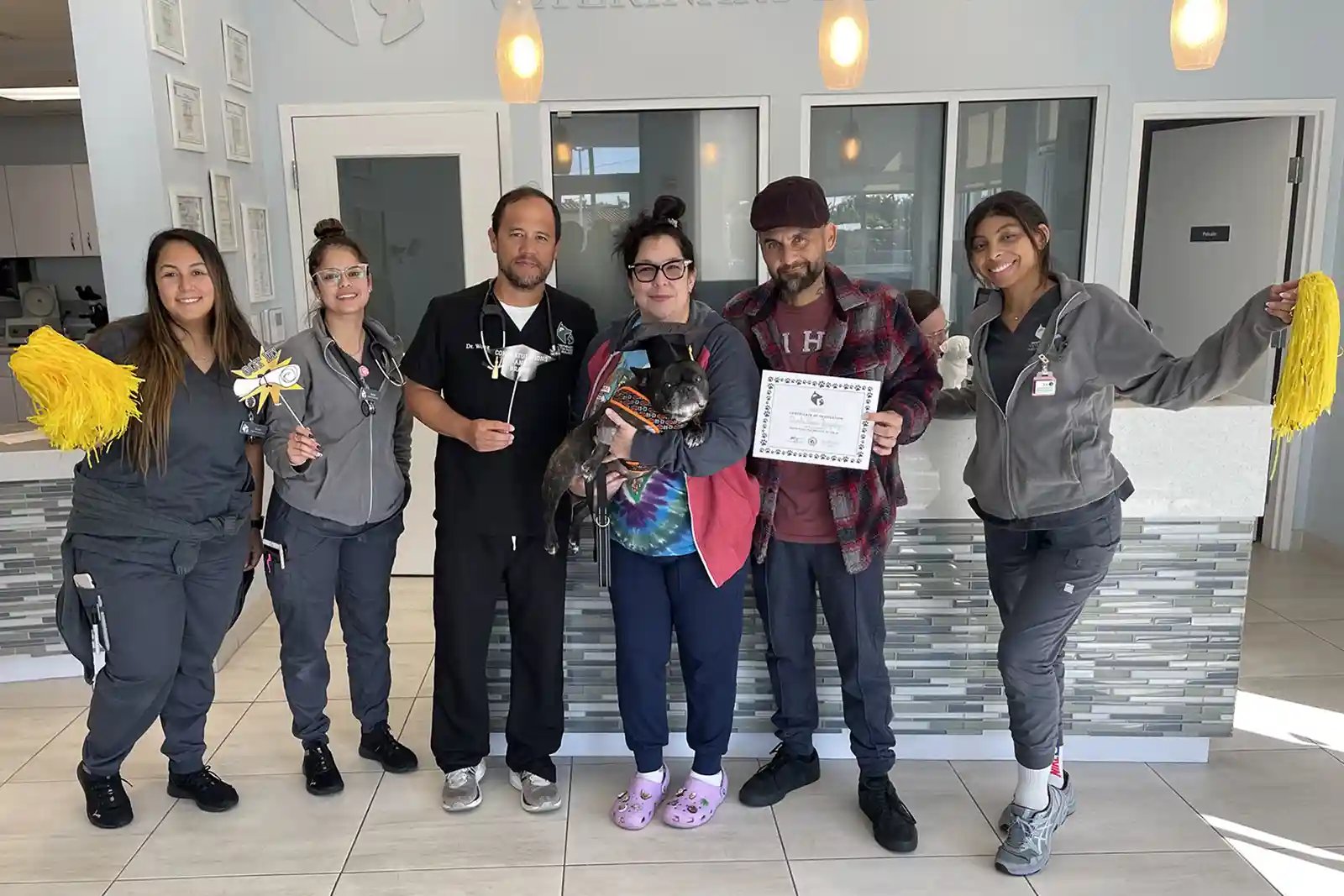 Dr. Wong and team celebrating a dog being treated for seizures successfully